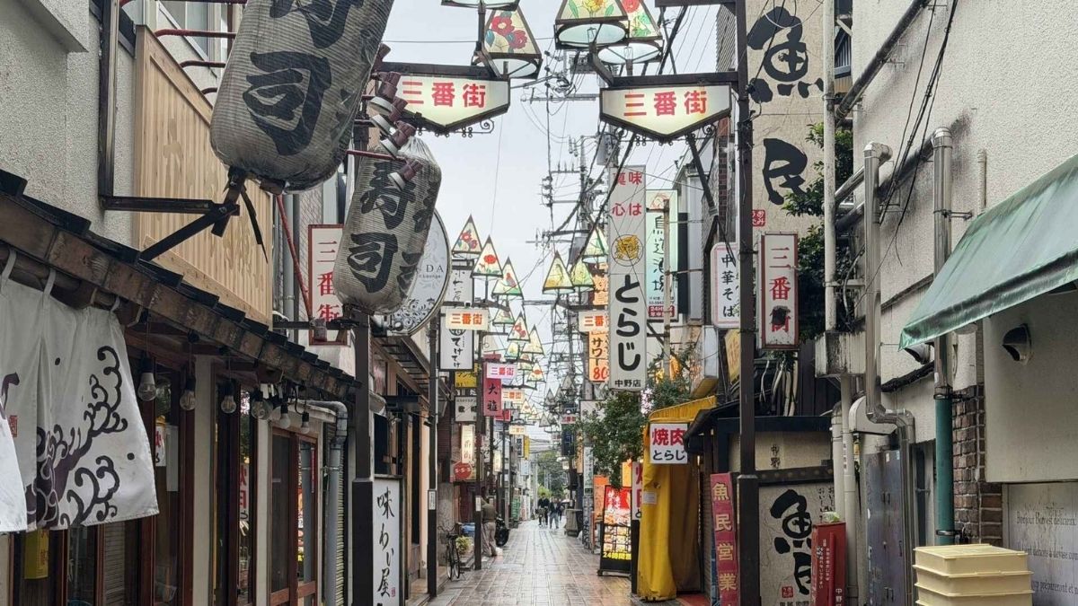 Lanterns and stacked shop signs in Nakano's Sanbangai alley, the evening end of the route