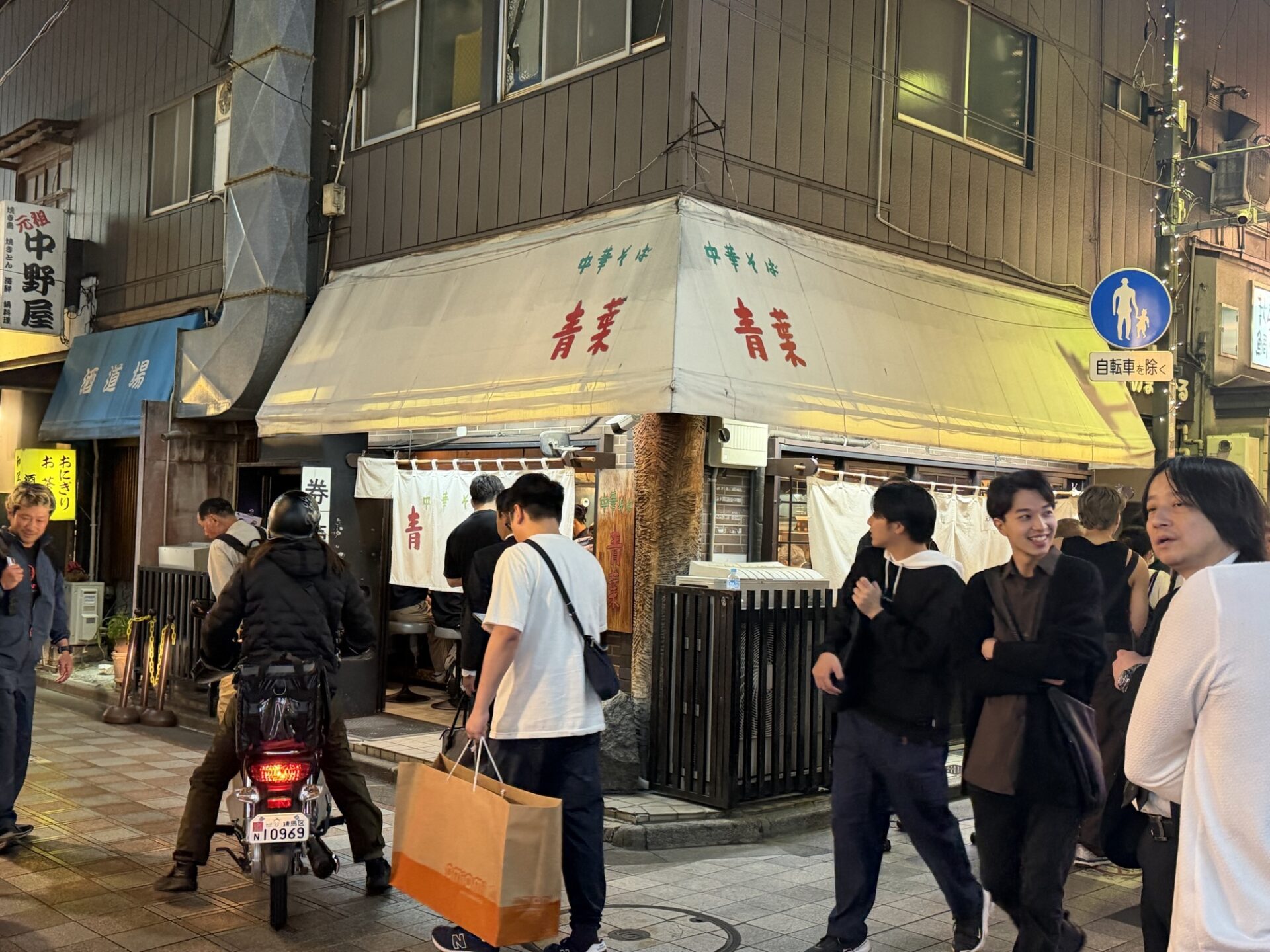 Chuka Soba Aoba Nakano Honten on its corner at night, with customers gathered outside