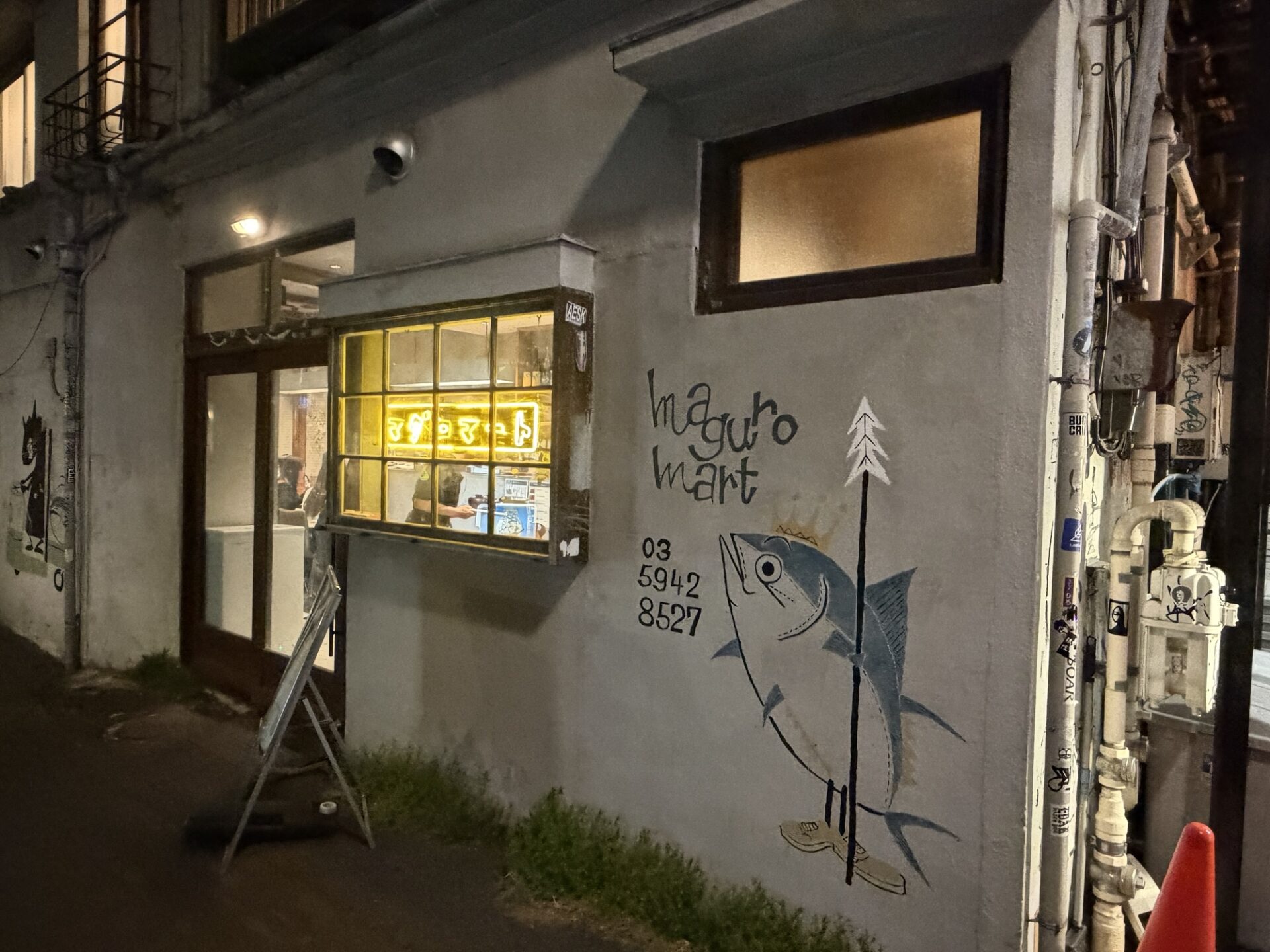 Maguro Mart Nakano's painted tuna mural and neon sign glowing in the window